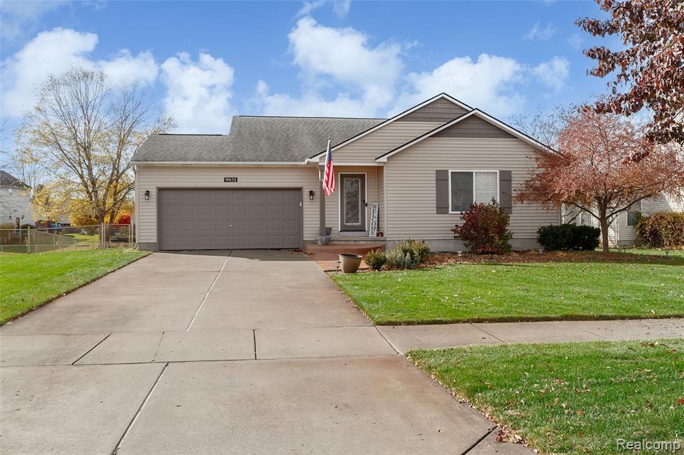 Ranch-style home featuring concrete driveway, an attached garage, and roof with shingles