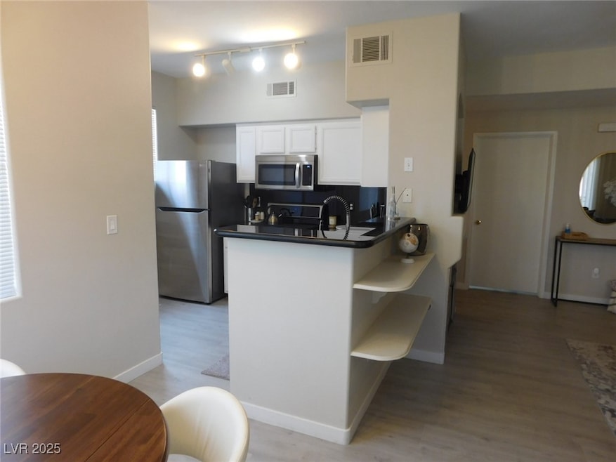 Kitchen with stainless steel appliances, white cab