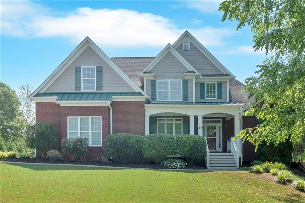 Craftsman-style house featuring brick siding, a front yard, and a standing seam roof