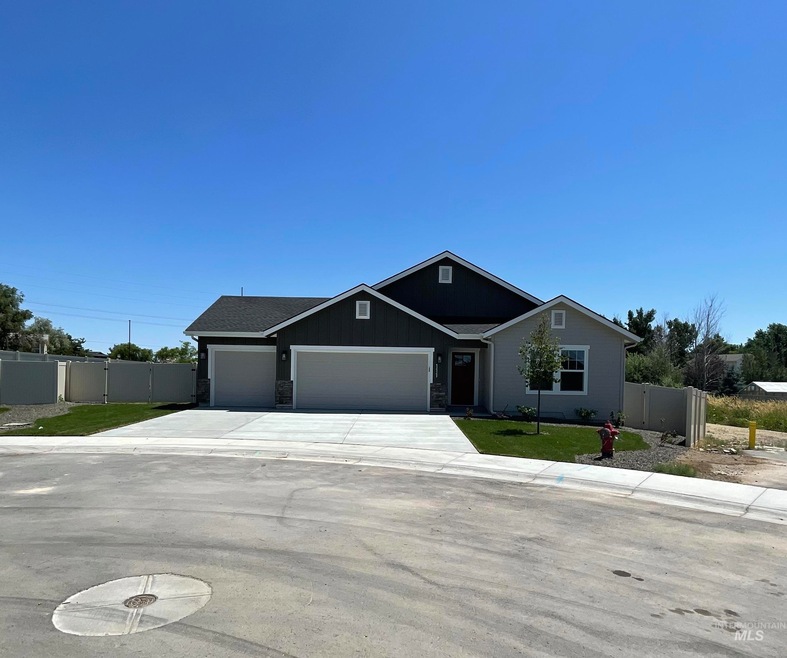 View of front facade with an attached garage, concrete driveway, and a gate