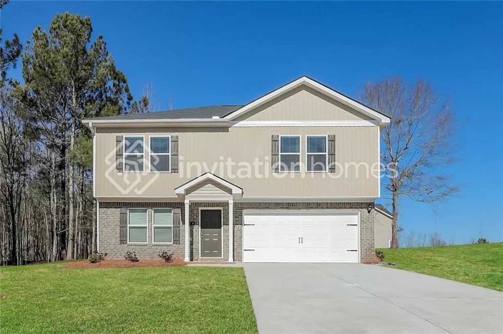 View of front facade featuring a front yard and a garage