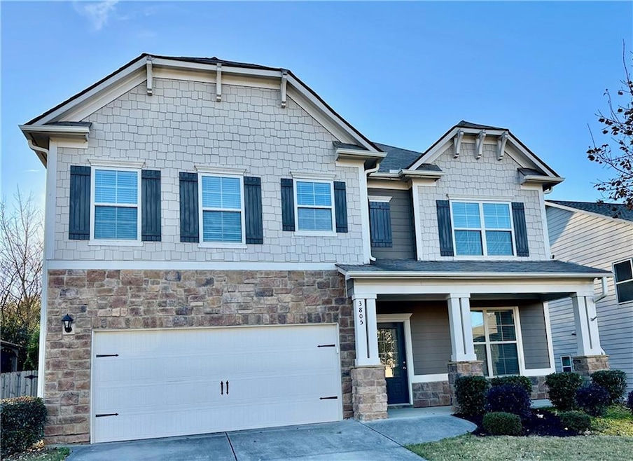 Craftsman inspired home featuring stone siding, a porch, driveway, and a garage