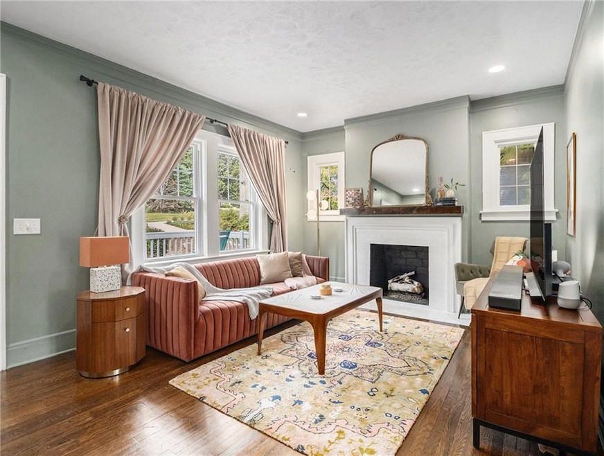 Living room with a textured ceiling, a brick firep