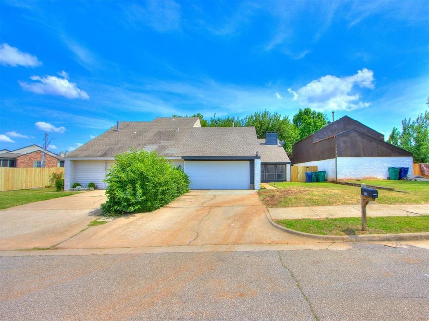 View of front of home with concrete driveway, an attached garage, and a chimney