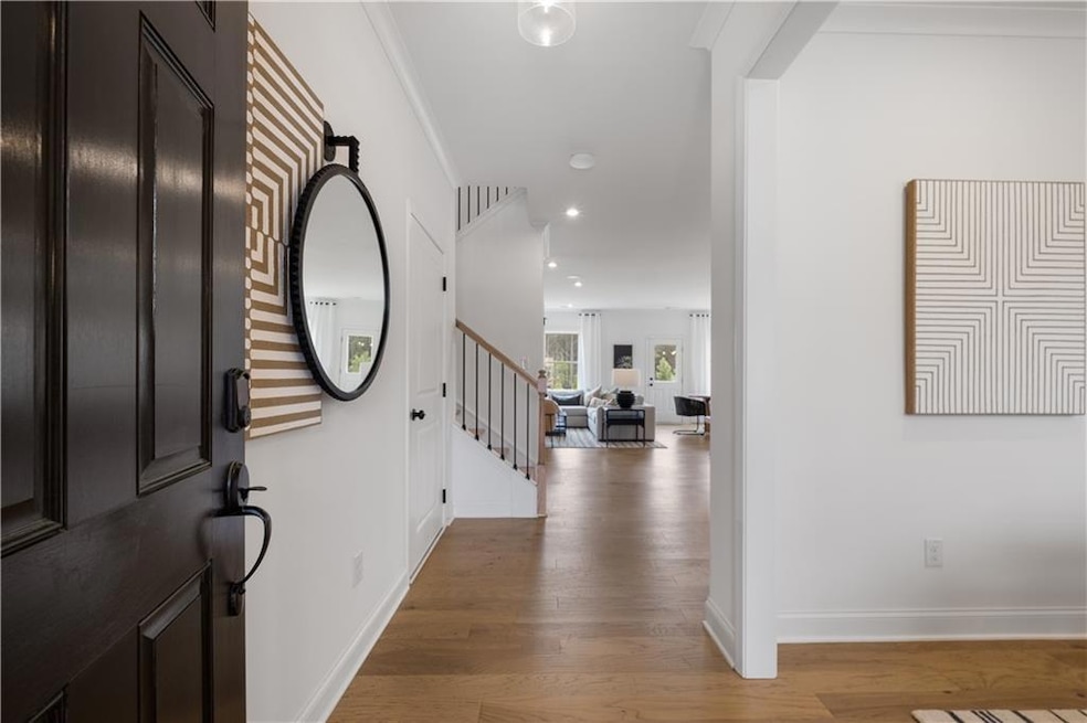 Entrance foyer with hardwood / wood-style floors and crown molding