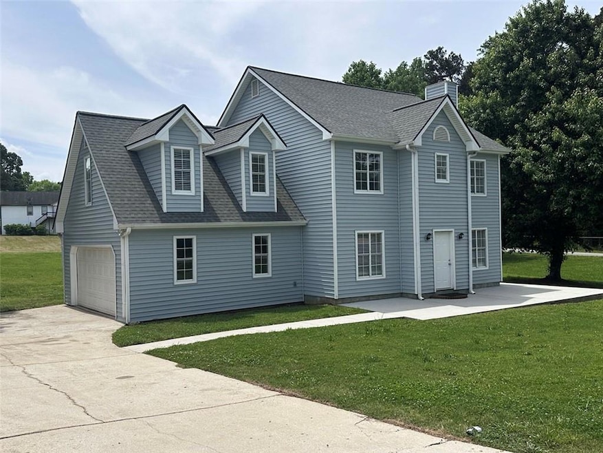 View of front of house featuring a front lawn, a g