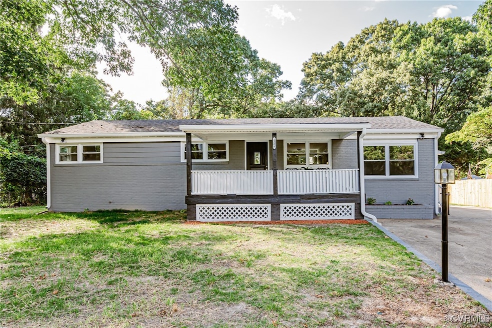 Ranch-style home featuring a front lawn and covered porch