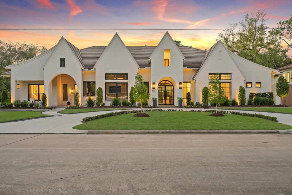 A circle driveway and Cantera front doors invite you into this custom masterpiece. The stucco front elevation with composite cedar shake roof is fully landscaped and has architectural design out of a magazine. Note the guest entrance to the left with a sitting porch.