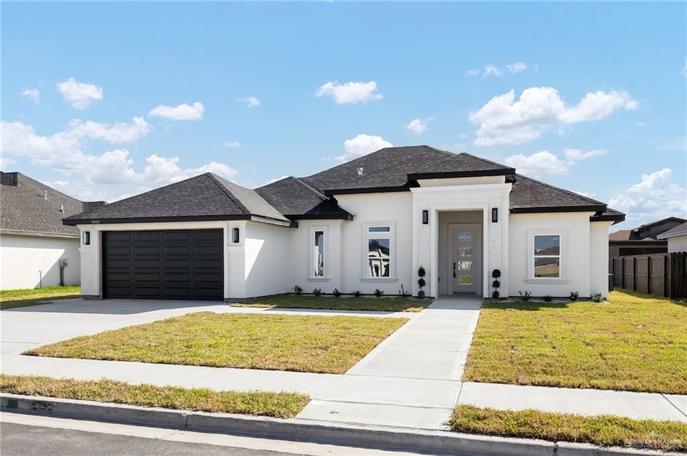 View of front of house with a front yard, an attached garage, and roof with shingles