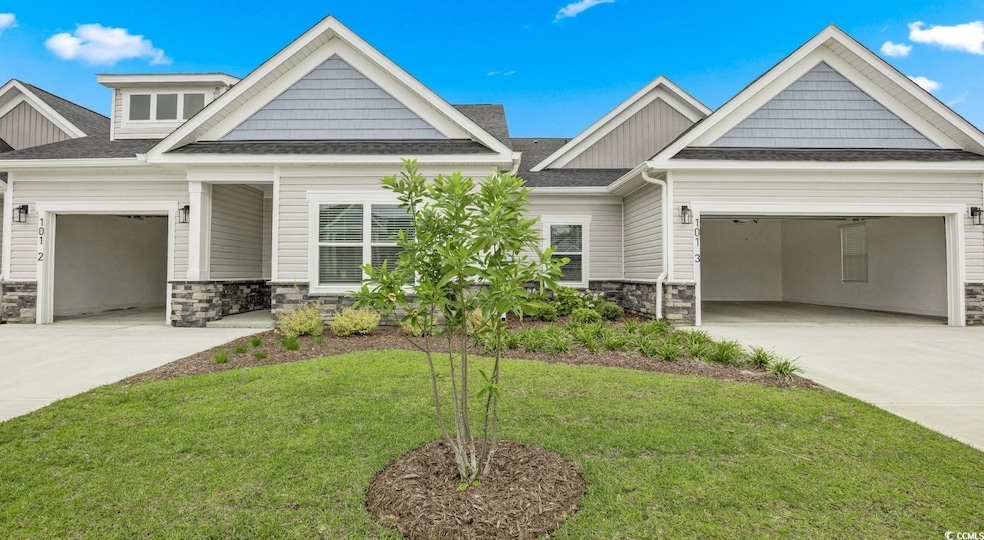 Craftsman-style home with stone siding, a garage, and roof with shingles