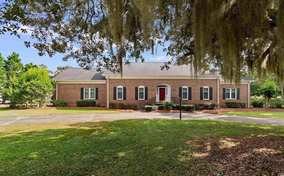 View of front of property featuring a front lawn, brick siding, and roof with shingles