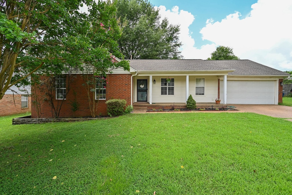 Ranch-style house featuring an attached garage, concrete driveway, a front yard, covered porch, and brick siding