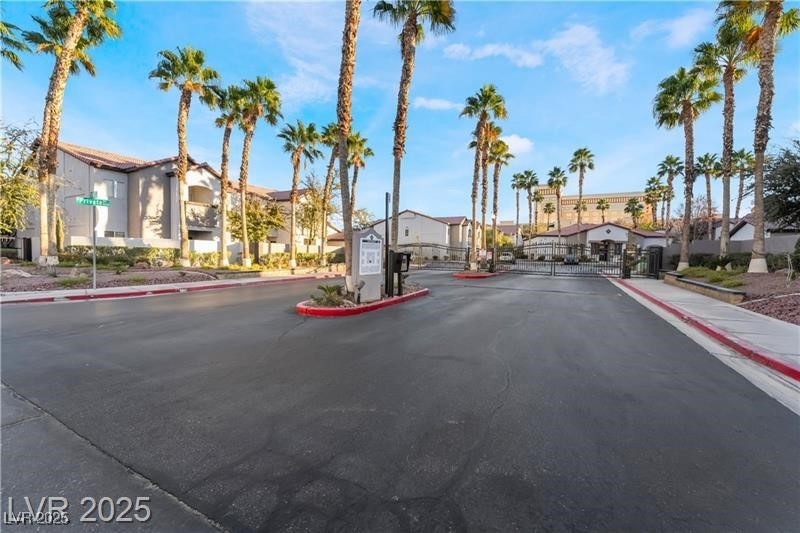 View of street featuring curbs, a gate, sidewalks,
