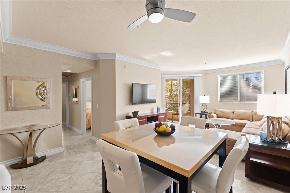 Dining space featuring crown molding, a ceiling fan, and light tile patterned floors