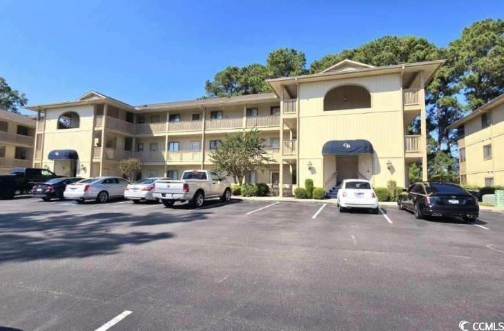 View of property featuring uncovered parking