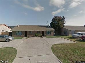View of front facade with driveway and a front yar