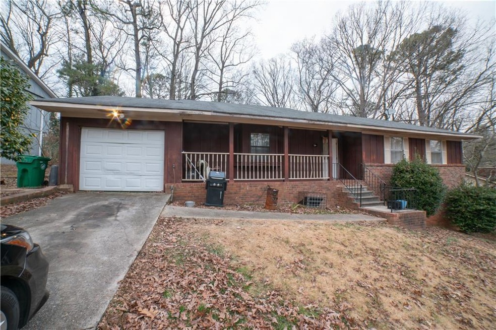 Ranch-style home with a garage and a porch