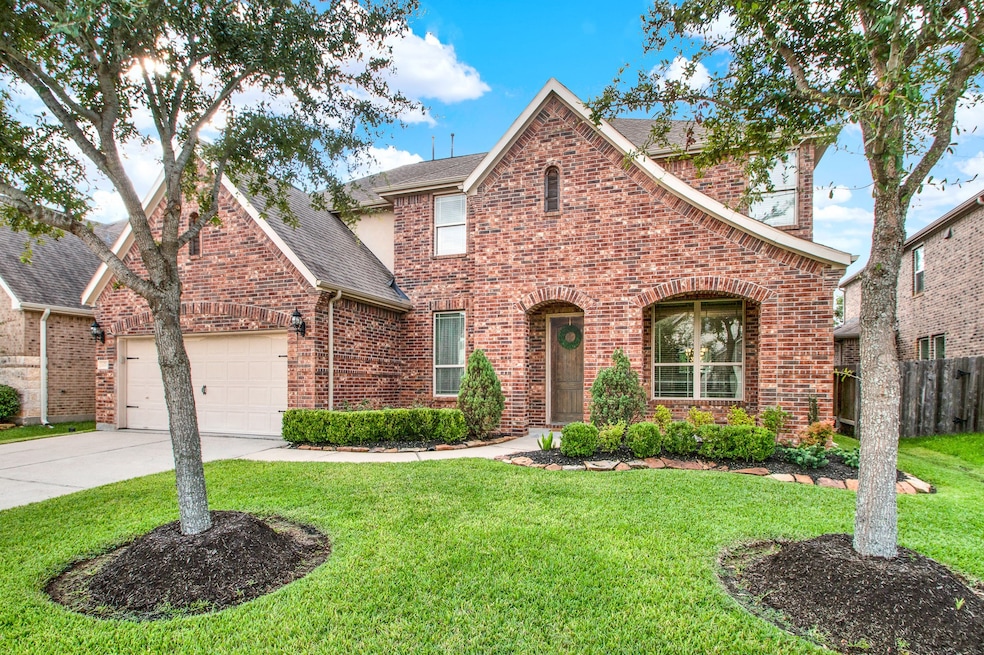 This stately brick home features a welcoming arche