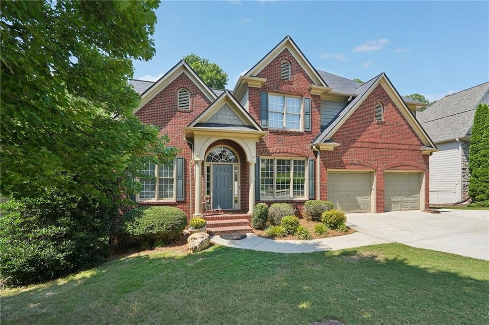 Traditional-style home with brick siding, concrete driveway, a front lawn, and a garage