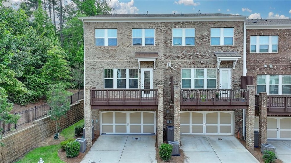 View of front facade featuring driveway, a garage, and brick siding