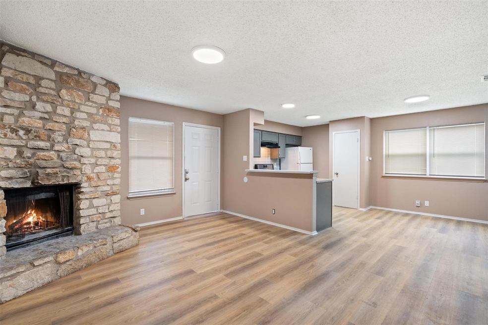 Unfurnished living room with a stone fireplace, l