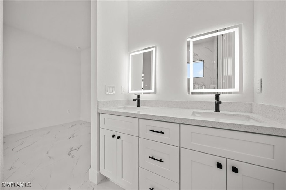 Full bath with marble look tile flooring and doubl