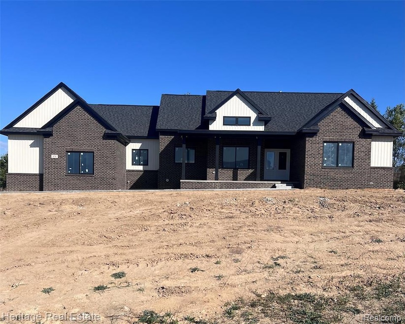 Modern inspired farmhouse with brick siding, a porch, and a shingled roof