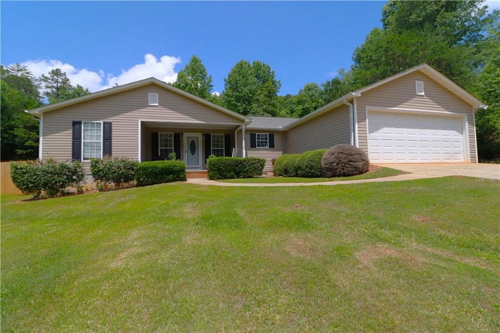 Single story home with a garage and a front lawn