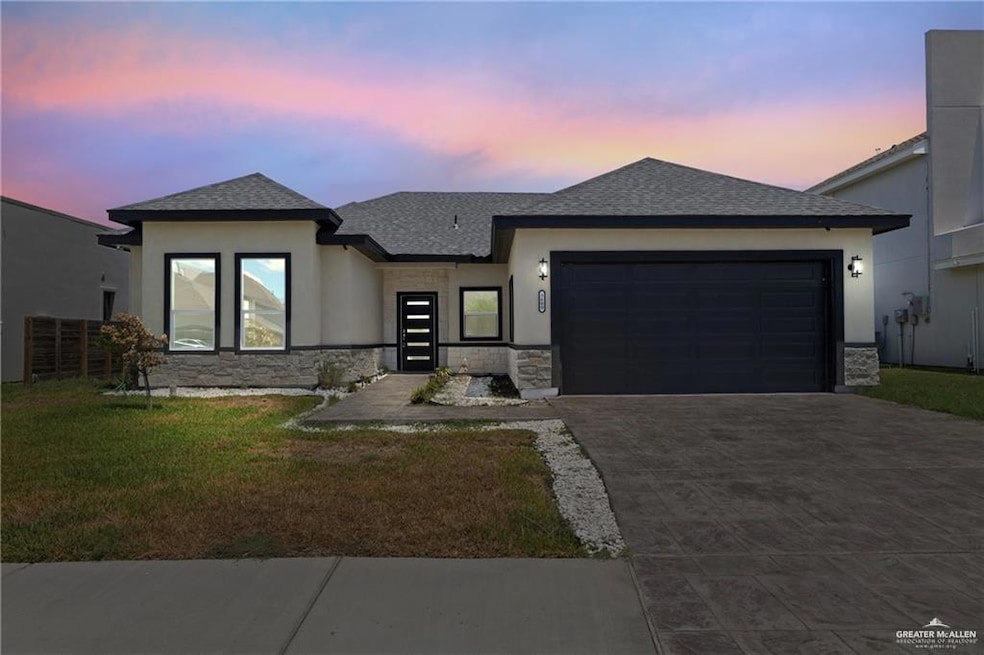 View of front of house with stone siding, stucco siding, and roof with shingles
