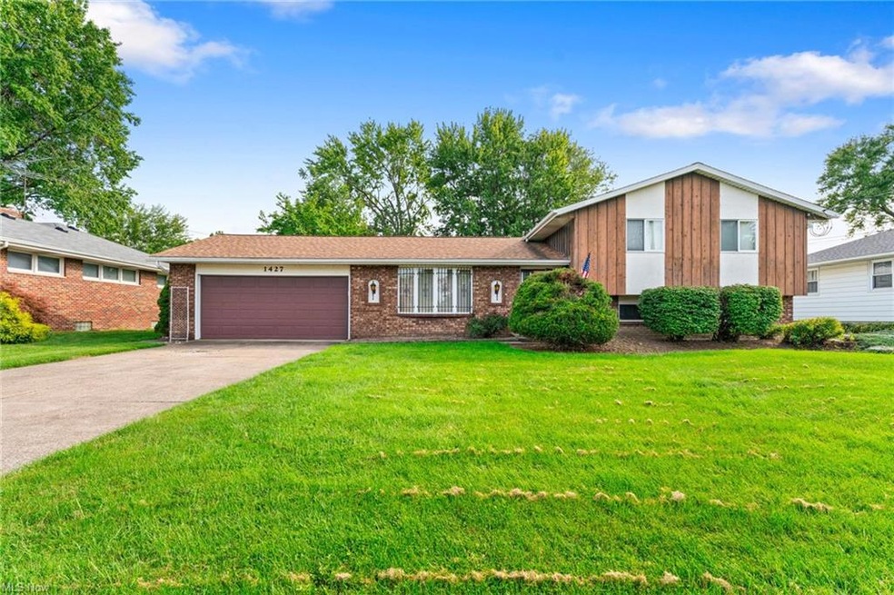 Split level home with garage and a front lawn