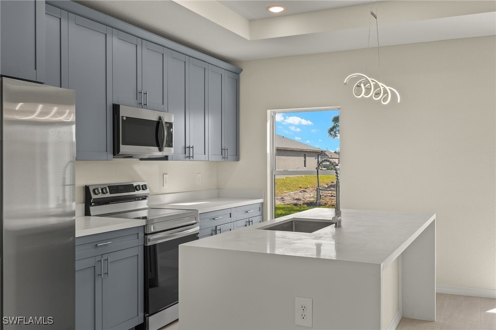 Kitchen featuring decorative light fixtures, sink,