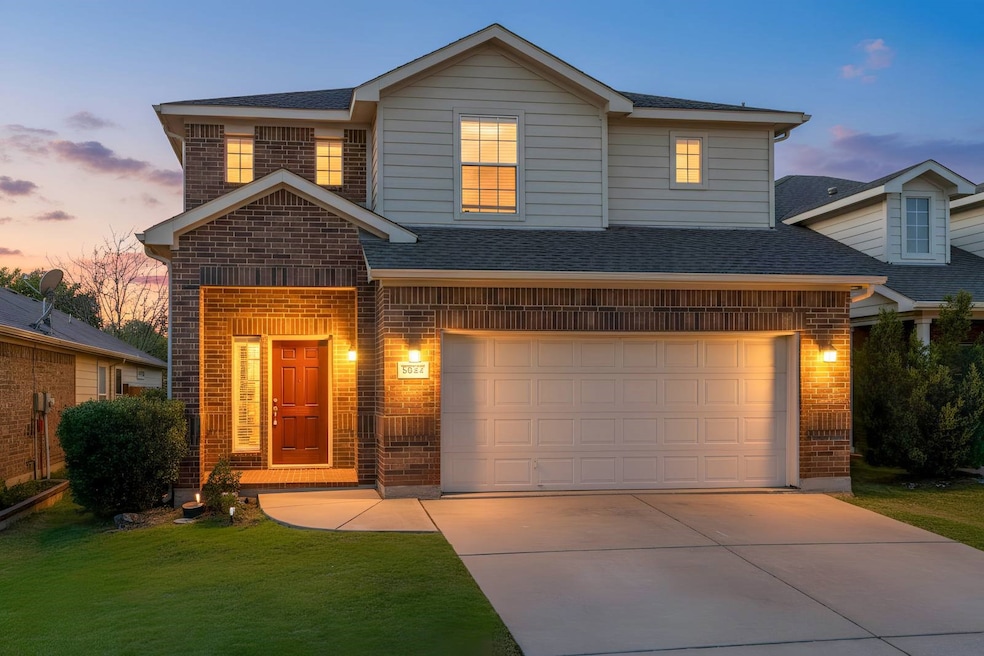 View of front of property with brick siding, roof with shingles, a front yard, and driveway