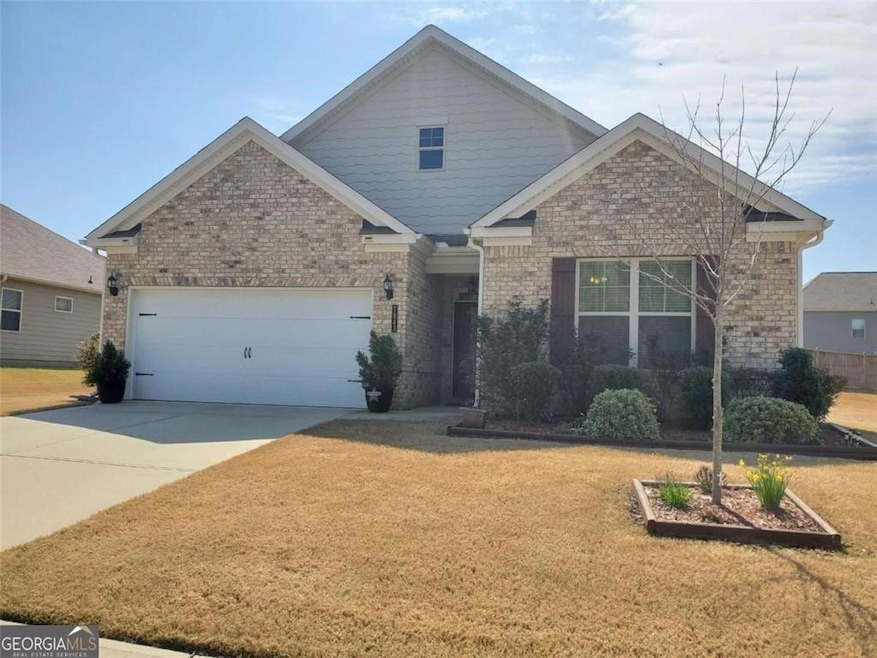 Craftsman house with brick siding, an attached garage, concrete driveway, and a front yard