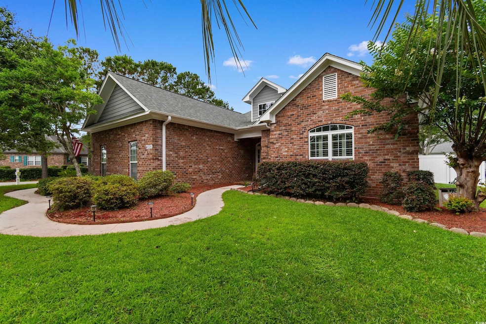 Traditional-style home with brick siding, a front lawn, and a shingled roof