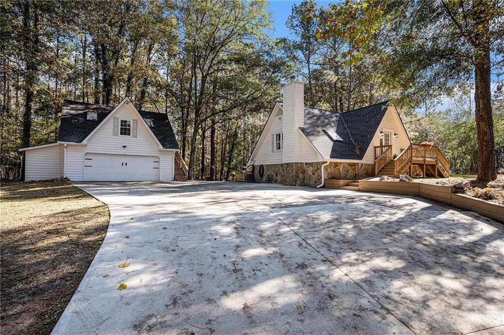 View of side of property featuring stairs, a shingled roof, stone siding, and a chimney