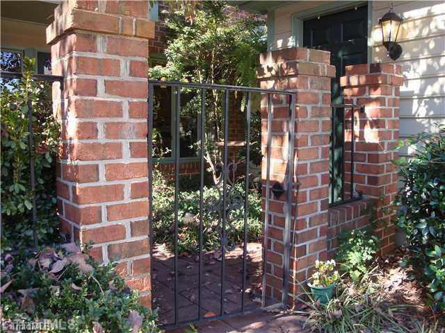 Exterior Front. Inviting entry has lovely iron gate and lots of greenery to welcome you!!