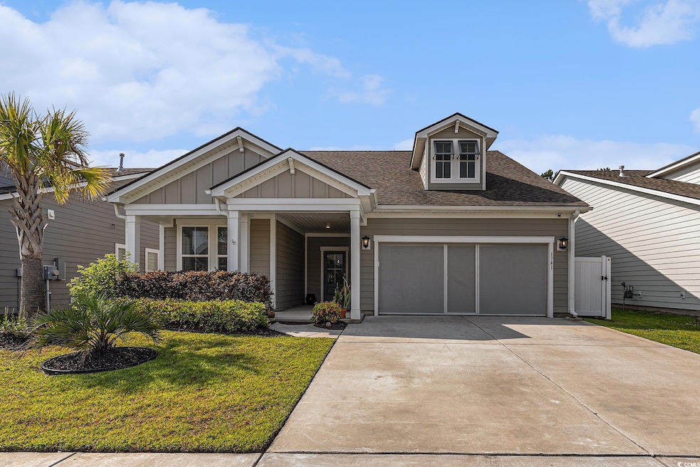 View of front of house featuring board and batten siding, an attached garage, a front yard, driveway, and roof with shingles