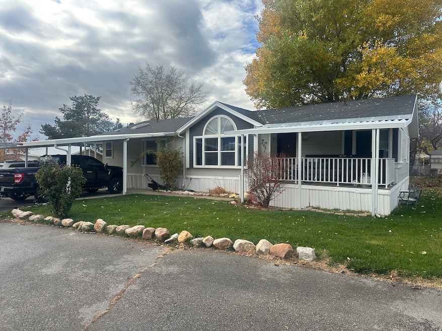 View of front facade featuring a front yard, a carport, and covered porch