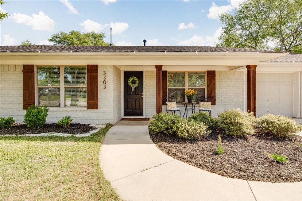 View of exterior entry with brick siding, a lawn,