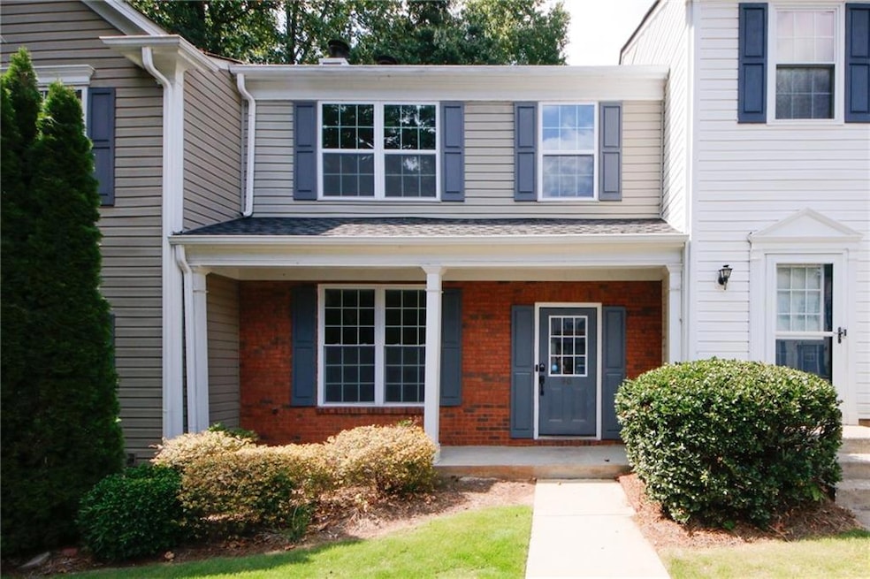 Doorway to property featuring brick siding and a porch