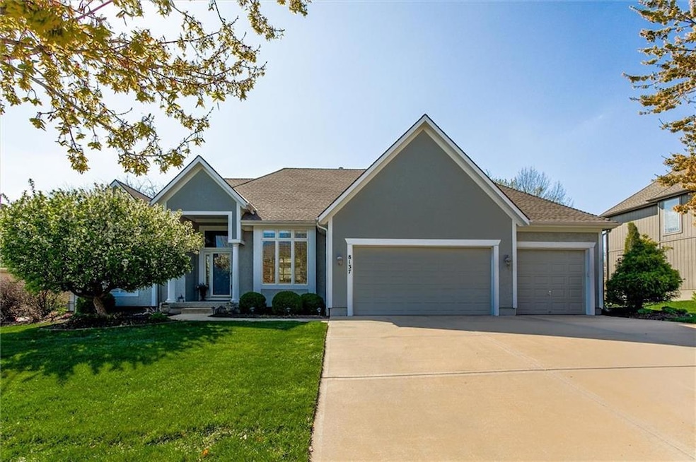 Ranch-style home with an attached garage, concrete driveway, stucco siding, and a front lawn