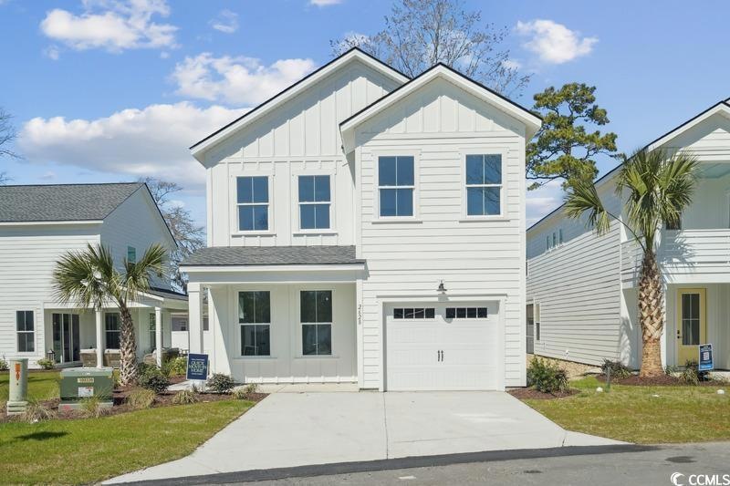 View of front facade featuring driveway, board and