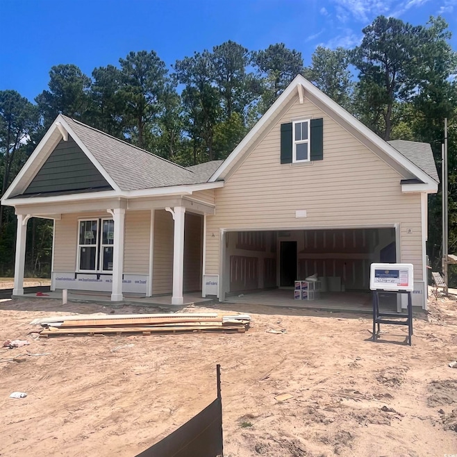 View of front of house with covered porch, a shingled roof, and driveway