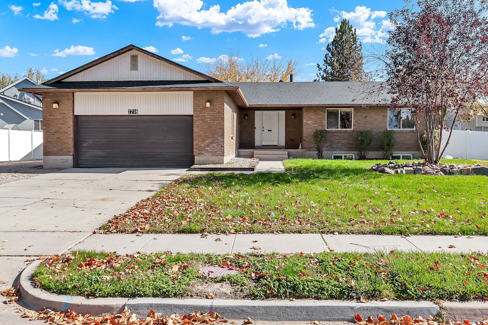 View of front facade with brick siding, concrete driveway, and an attached garage