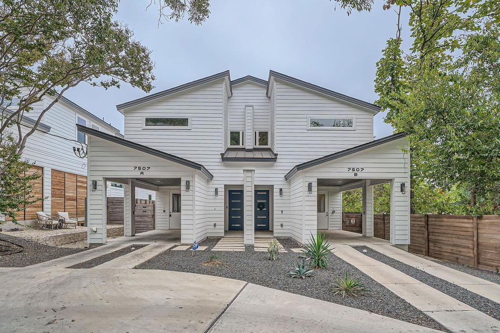 View of front facade with driveway and fence
