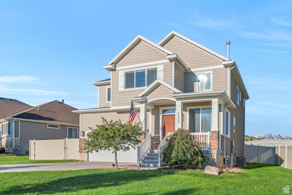 View of front facade featuring a gate, concrete driveway, stone siding, and a garage