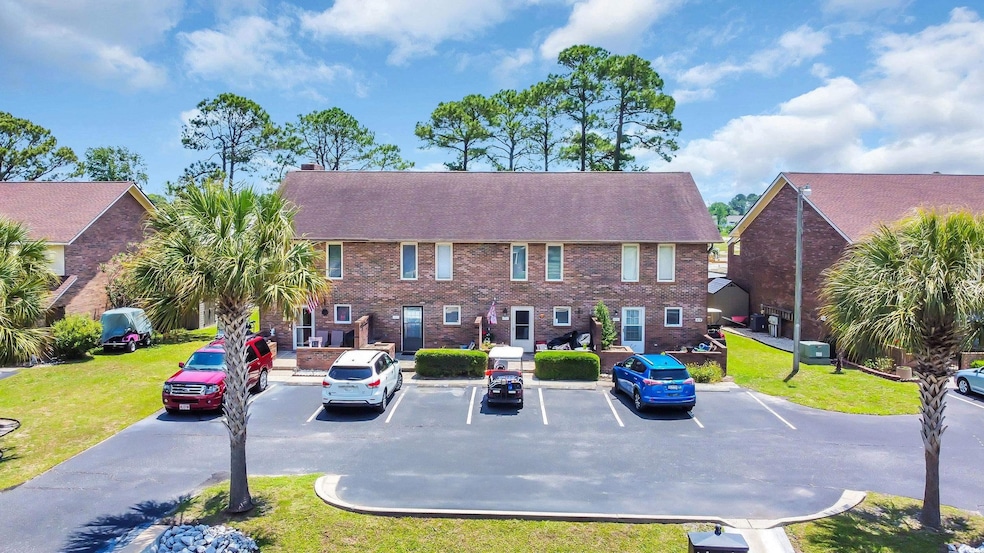 View of building exterior with uncovered parking