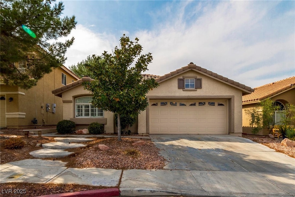 View of front of house featuring driveway, a tiled