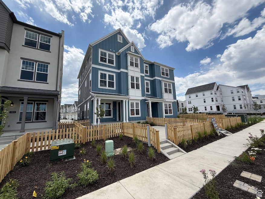 View of front facade featuring a residential view, board and batten siding, and a fenced front yard