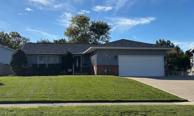 Ranch-style home featuring a front yard, brick siding, concrete driveway, and an attached garage